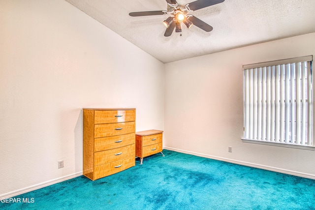 unfurnished bedroom with lofted ceiling, a textured ceiling, dark colored carpet, and ceiling fan