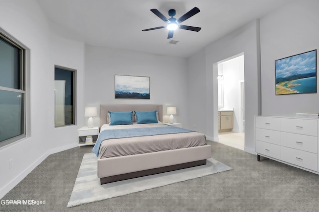 carpeted bedroom with ceiling fan, baseboards, ensuite bathroom, and visible vents
