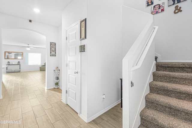 staircase with ceiling fan and wood-type flooring