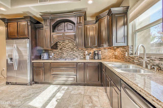 kitchen featuring dark brown cabinets, stainless steel appliances, tasteful backsplash, and sink