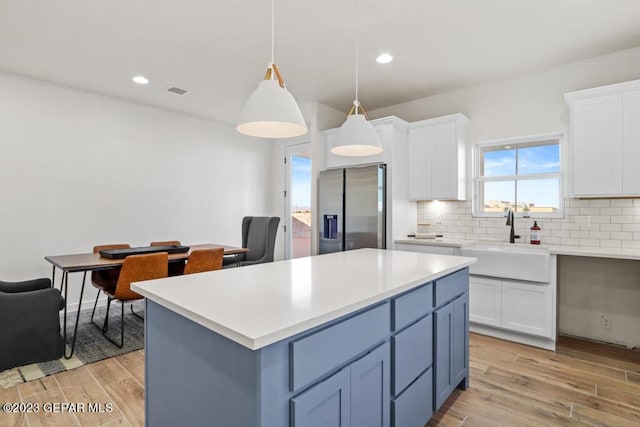 205 Playa Vista St, El Paso, TX 79928 - kitchen featuring stainless steel refrigerator with ice dispenser, a sink, white cabinetry, tasteful backsplash, and light wood-type flooring
