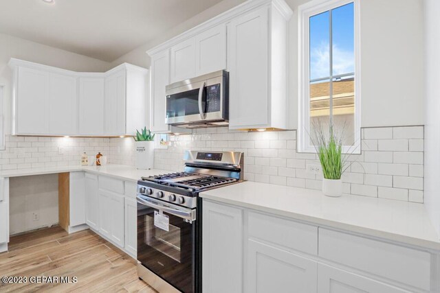 205 Playa Vista St, El Paso, TX 79928 - kitchen featuring appliances with stainless steel finishes, white cabinets, light countertops, and decorative backsplash