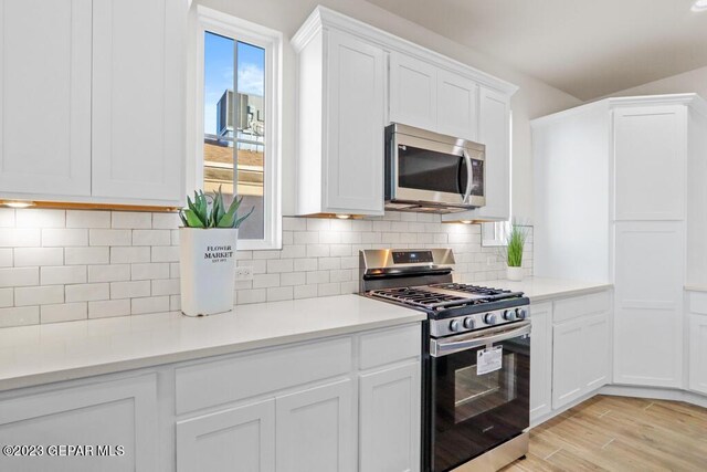 205 Playa Vista St, El Paso, TX 79928 - kitchen with stainless steel appliances, white cabinetry, light countertops, light wood-style flooring, and tasteful backsplash