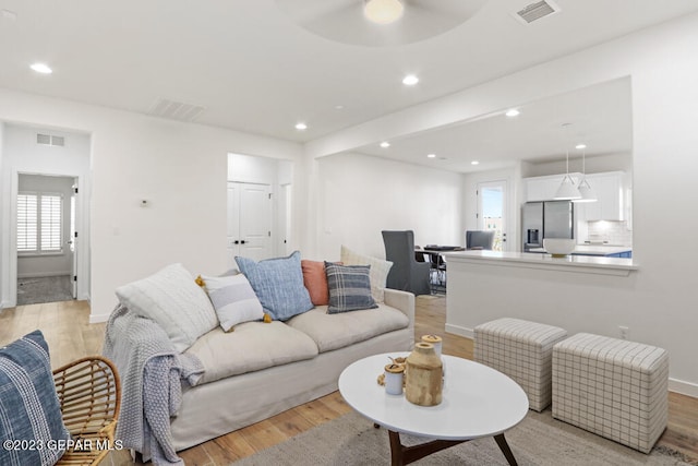 living room with light wood-type flooring and ceiling fan