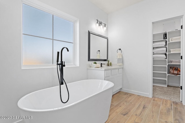 bathroom featuring vanity, a bath, and hardwood / wood-style flooring