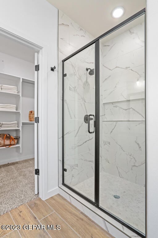 bathroom featuring wood-type flooring and walk in shower