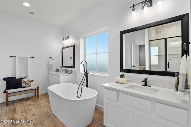 bathroom with vanity, wood-type flooring, and independent shower and bath