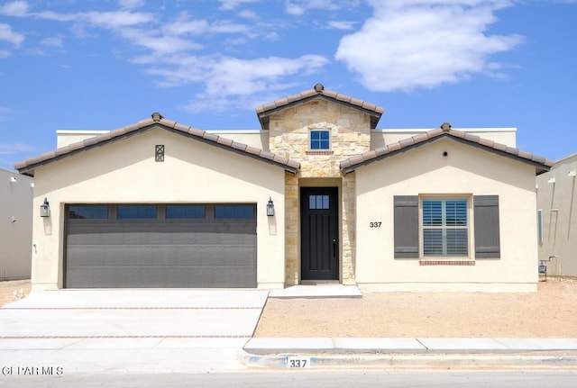 208 Playa Vista St, Horizon City, TX 79928 - view of front of house with an attached garage, concrete driveway, stone siding, stucco siding, and a tile roof