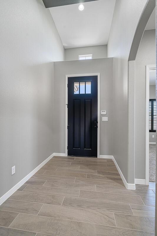 208 Playa Vista St, Horizon City, TX 79928 - entryway featuring arched walkways, plenty of natural light, baseboards, and wood finish floors
