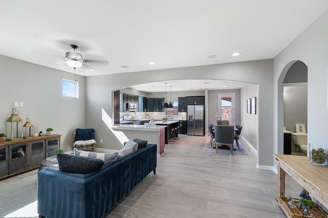 living room featuring ceiling fan and light wood-type flooring