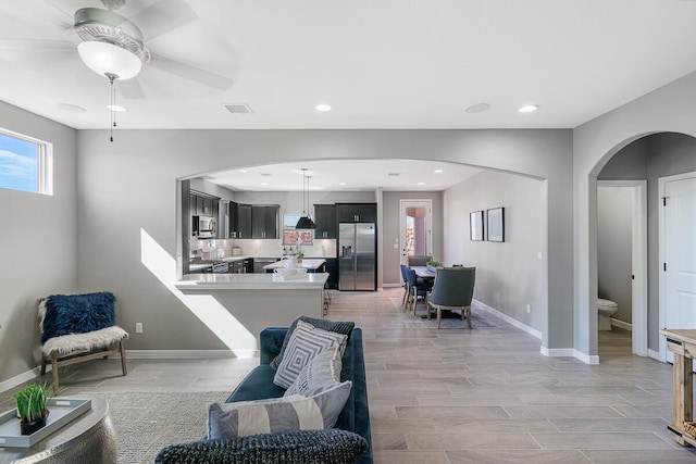 living room with ceiling fan and light wood-type flooring