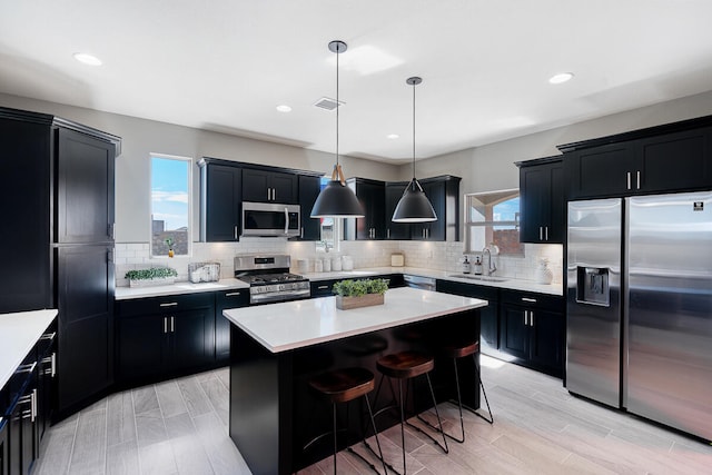 kitchen with a kitchen breakfast bar, a center island, a healthy amount of sunlight, and appliances with stainless steel finishes