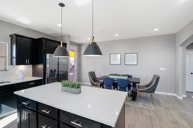 208 Playa Vista St, Horizon City, TX 79928 - kitchen featuring stainless steel fridge with ice dispenser, dark cabinets, light countertops, baseboards, and recessed lighting