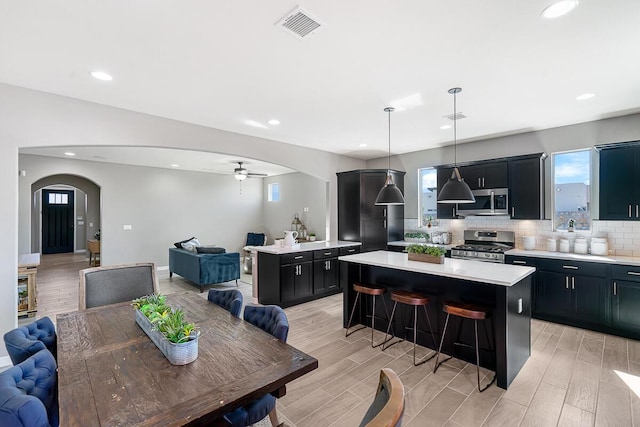 208 Playa Vista St, Horizon City, TX 79928 - kitchen with stainless steel appliances, open floor plan, arched walkways, a center island, and recessed lighting