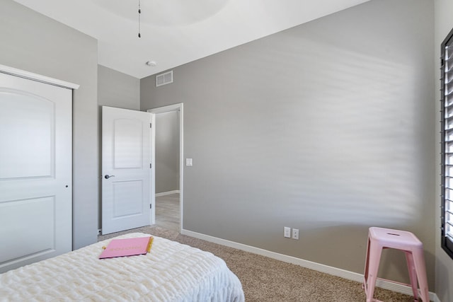 bedroom with light carpet, vaulted ceiling, and a closet