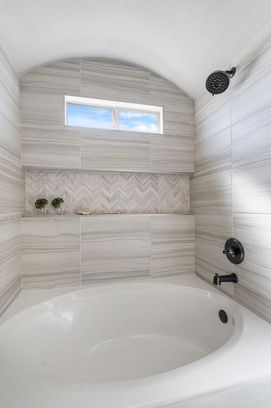 208 Playa Vista St, Horizon City, TX 79928 - bathroom with vaulted ceiling and bathtub / shower combination