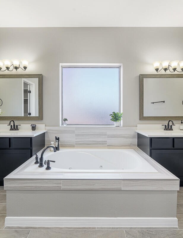 bathroom with vanity and tiled bath