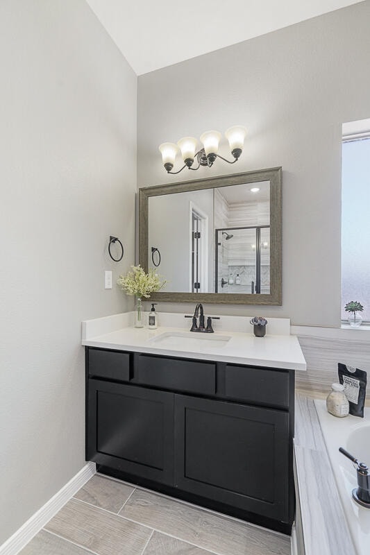 bathroom with hardwood / wood-style floors, vanity, and shower with separate bathtub