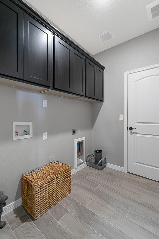 laundry room featuring washer hookup, cabinets, and hookup for an electric dryer