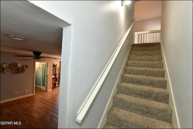 stairway with hardwood / wood-style flooring and ceiling fan