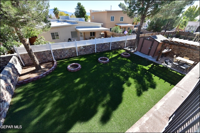 view of yard featuring a storage shed, an outdoor fire pit, and a patio