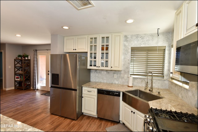 kitchen featuring sink, light stone counters, dark hardwood / wood-style flooring, and stainless steel appliances