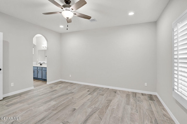 spare room featuring ceiling fan, light wood-type flooring, and sink