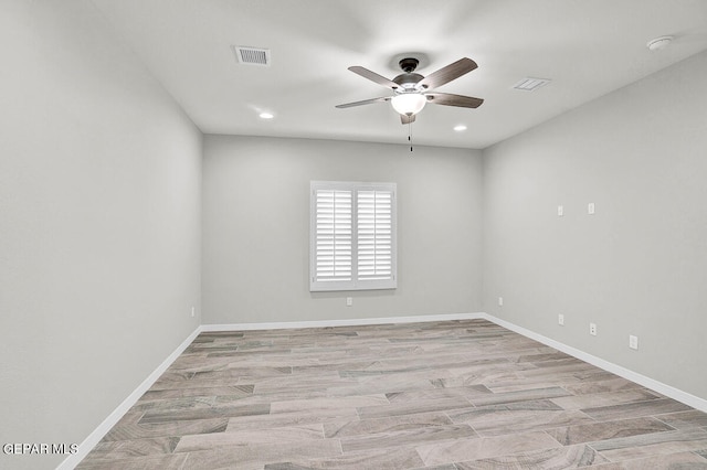 empty room with ceiling fan and light hardwood / wood-style flooring