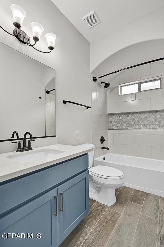 full bathroom featuring vanity, toilet, and tiled shower / bath