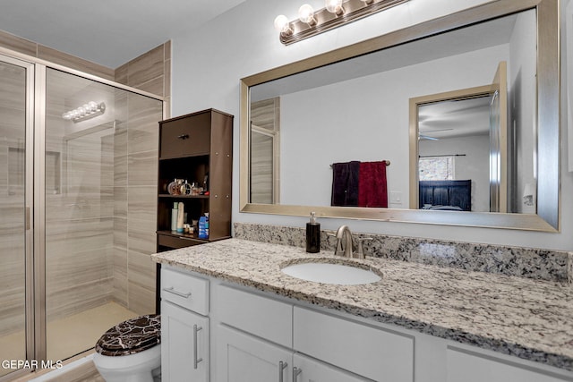 bathroom with vanity, toilet, and a shower with door