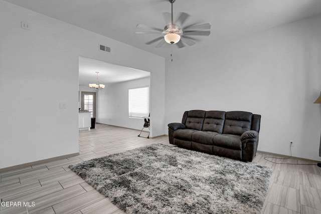 living room with ceiling fan with notable chandelier and light wood-type flooring