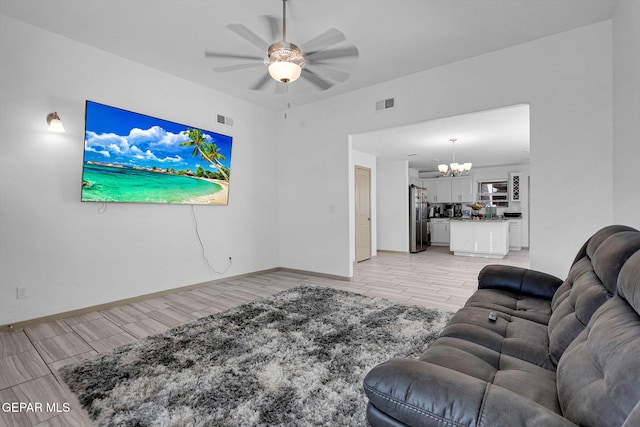 living room with ceiling fan with notable chandelier and light wood-type flooring