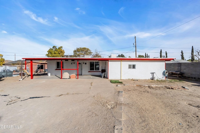 back of property with a carport