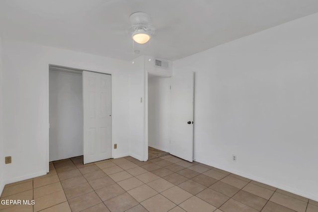 unfurnished bedroom featuring ceiling fan, a closet, and light tile patterned floors