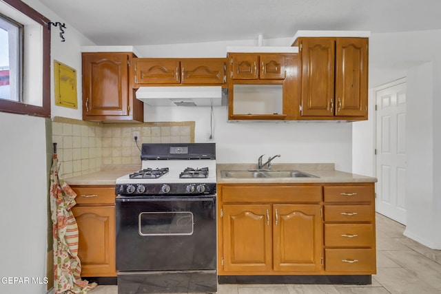 kitchen featuring black gas range, sink, vaulted ceiling, decorative backsplash, and light tile patterned flooring