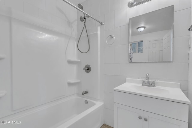 bathroom featuring decorative backsplash, vanity, tiled shower / bath combo, and tile walls