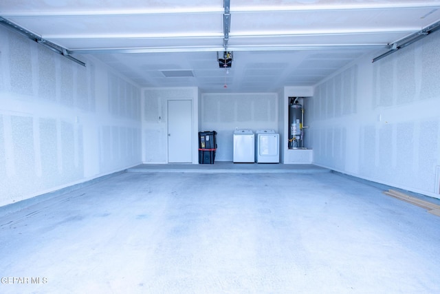 garage featuring separate washer and dryer, a garage door opener, and water heater