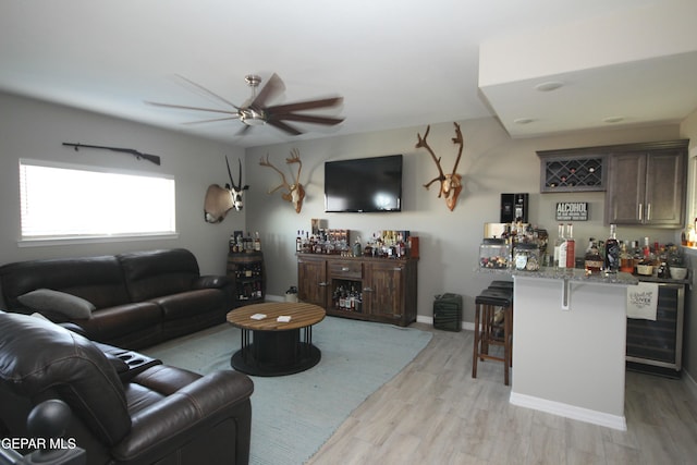 living room with indoor bar, ceiling fan, light wood-type flooring, and wine cooler