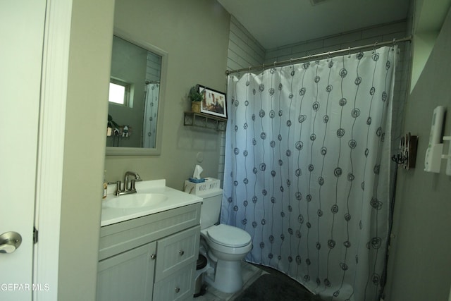 bathroom featuring toilet, walk in shower, and vanity