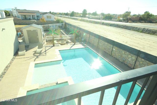 view of swimming pool featuring a patio area and a storage unit