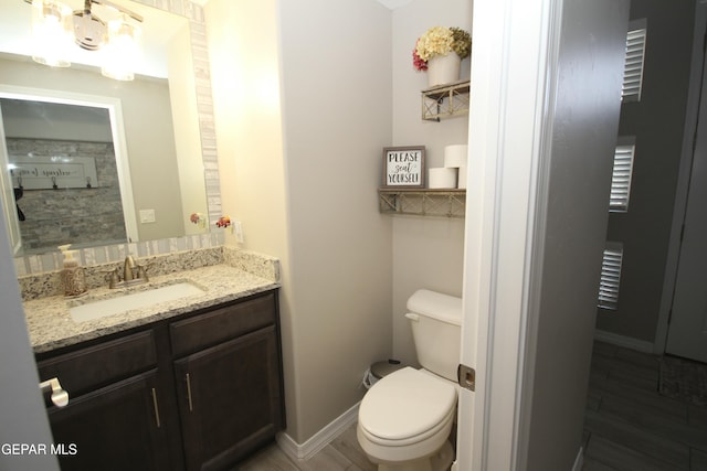 bathroom with toilet, vanity, and hardwood / wood-style floors