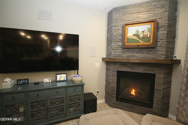 living room featuring light hardwood / wood-style floors and a stone fireplace