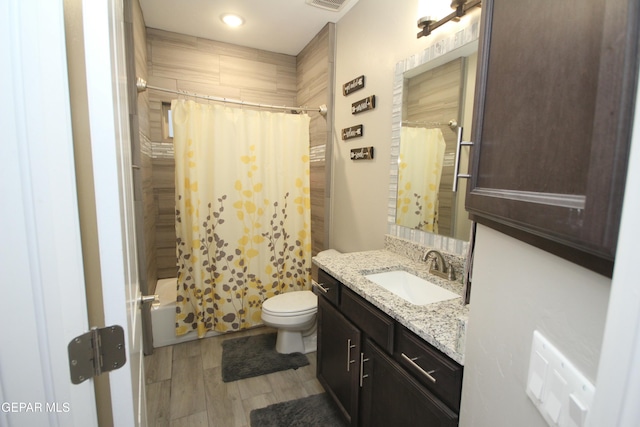 full bathroom with shower / bath combo with shower curtain, vanity, and toilet