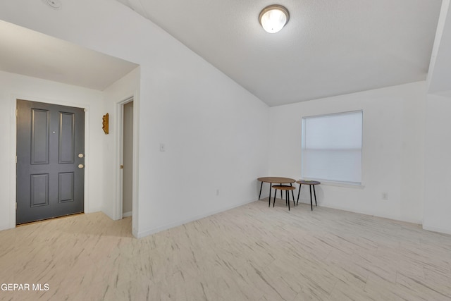 bonus room with a textured ceiling and vaulted ceiling