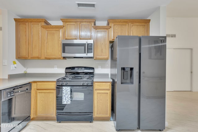 kitchen with light brown cabinets, light hardwood / wood-style floors, and black appliances