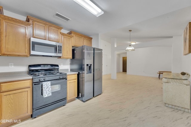 kitchen featuring light brown cabinets, stainless steel appliances, and decorative light fixtures