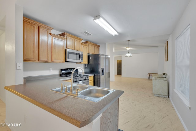 kitchen with kitchen peninsula, sink, stainless steel appliances, and decorative light fixtures