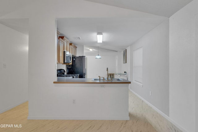 kitchen with sink, kitchen peninsula, light hardwood / wood-style floors, decorative light fixtures, and appliances with stainless steel finishes