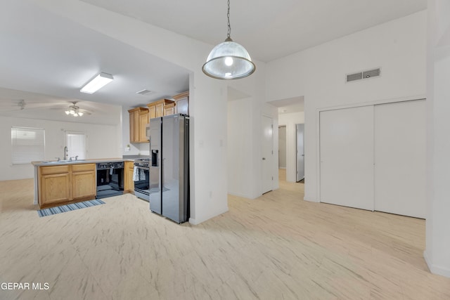 kitchen featuring gas range, dishwasher, kitchen peninsula, stainless steel fridge, and pendant lighting