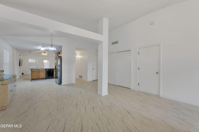 unfurnished living room featuring vaulted ceiling and ceiling fan